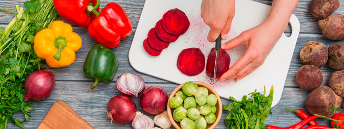 Gemüse, Kräuter, Schneidebrett, Messer, auf Holzhintergrund Rote Beete in Scheiben schneiden
