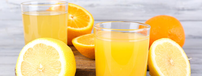 Glas mit Orangensaft auf Holztisch 