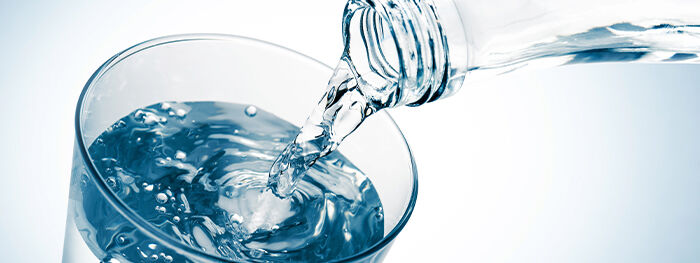 Wasser wird eingeschenkt ins Wasserglas
