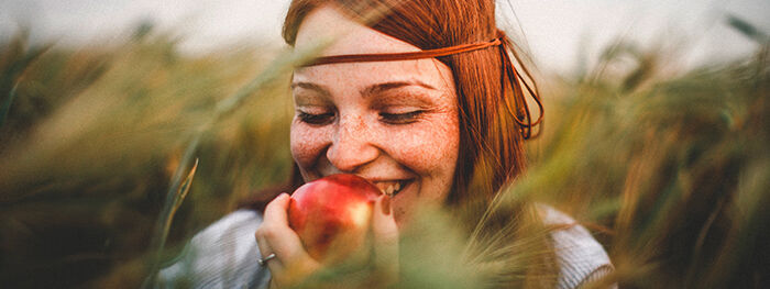 Frau beißt in Apfel, Frische, Bio-Qualität, Feld